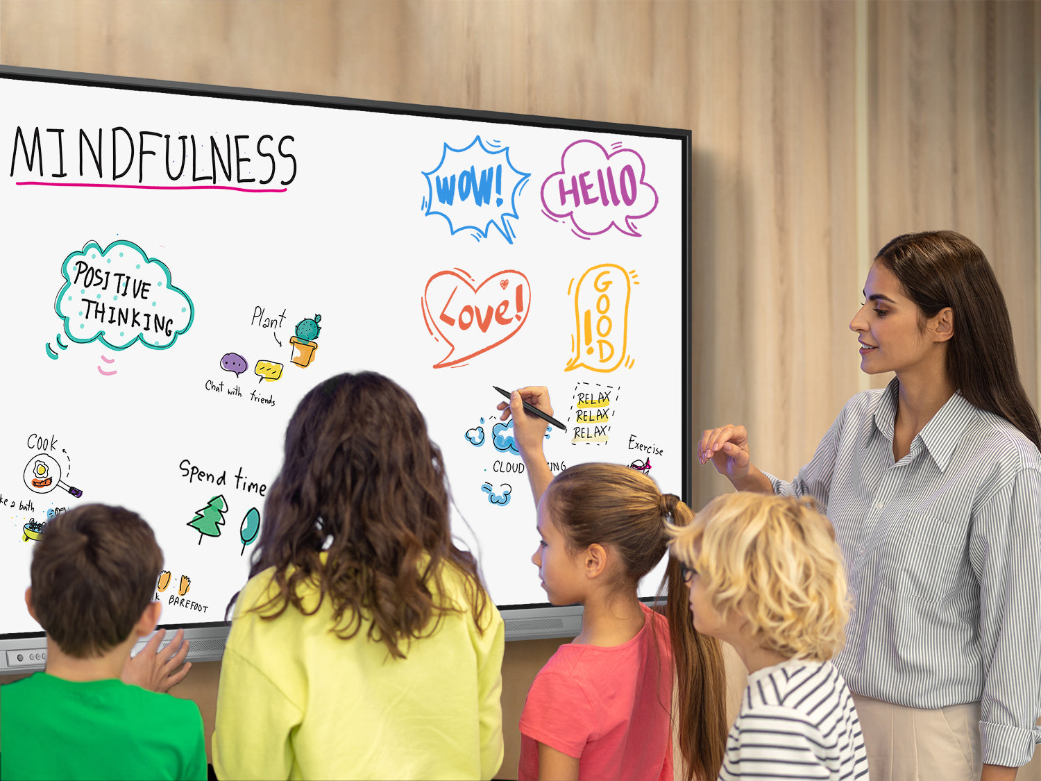 K-12 students collaborating on a smart board during a classroom mindfulness and creative group activity guided by the teacher