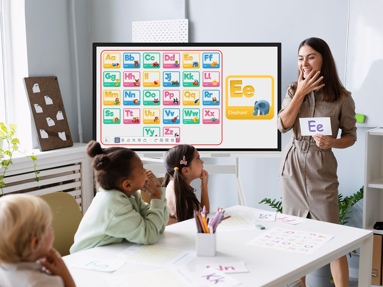 Teacher using a smart board to teach alphabet pronunciation to early K-12 learners in an engaging lesson